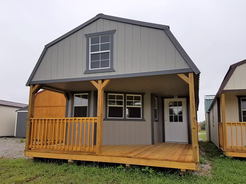 This is a 16x40 Wraparound Lofted Barn Cabin painted Lt. Gray with Dk. Gray Trim & a Charcoal metal roof.